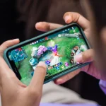 Monitor amplo exibindo painel de edição gráfica simultâneo a jogo em execução