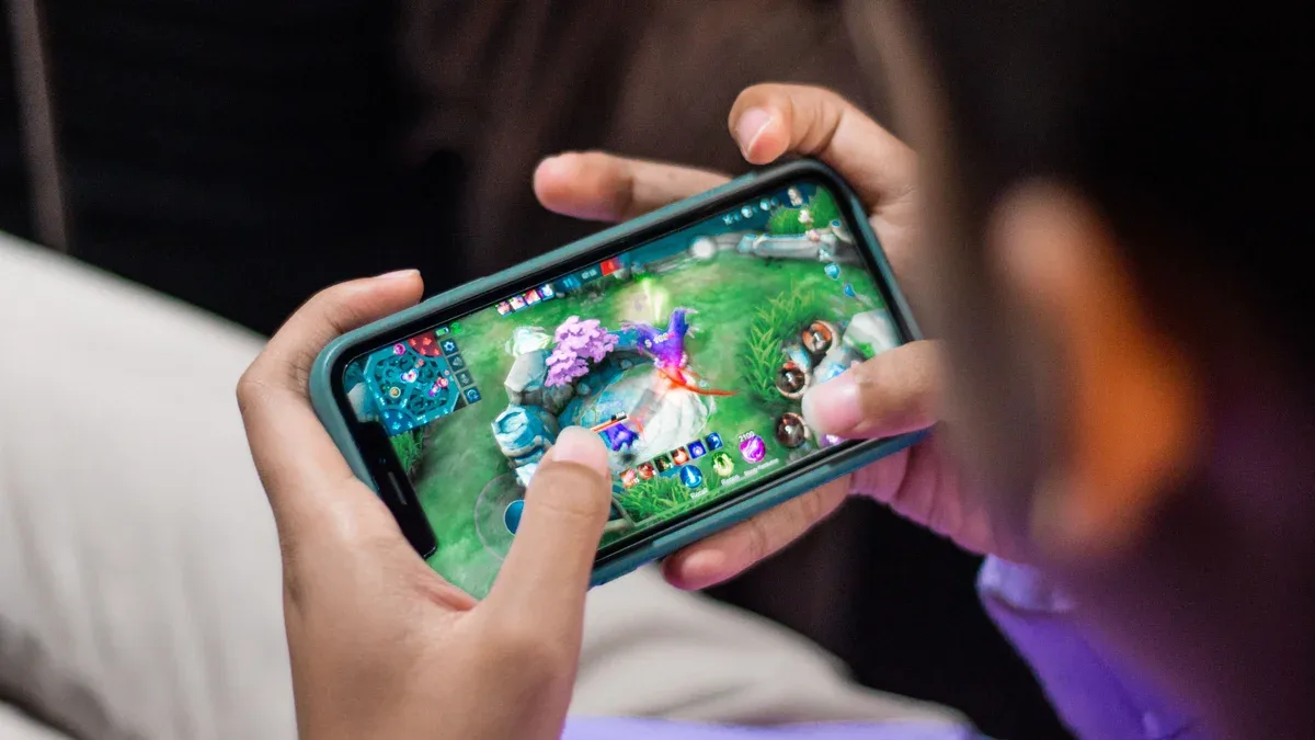 Monitor amplo exibindo painel de edição gráfica simultâneo a jogo em execução