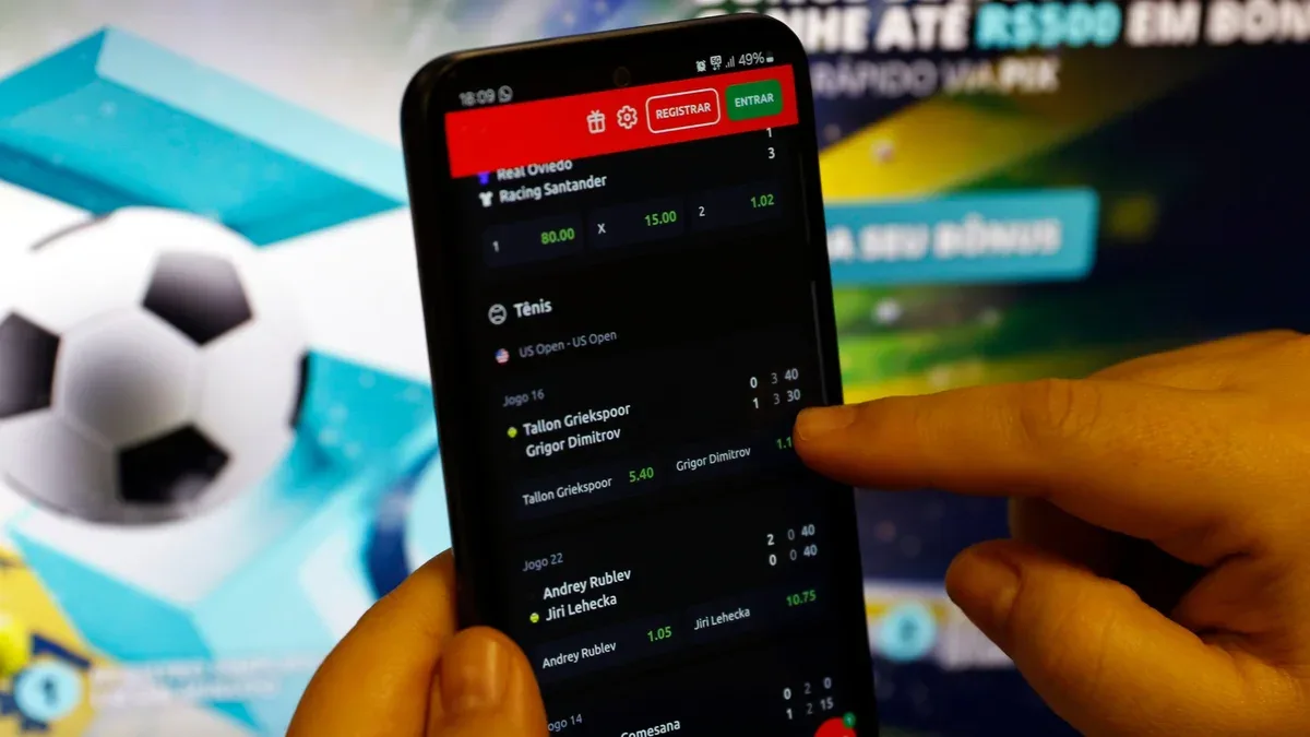 Smartphone exibindo aplicativo de apostas bloqueado em tela corporativa