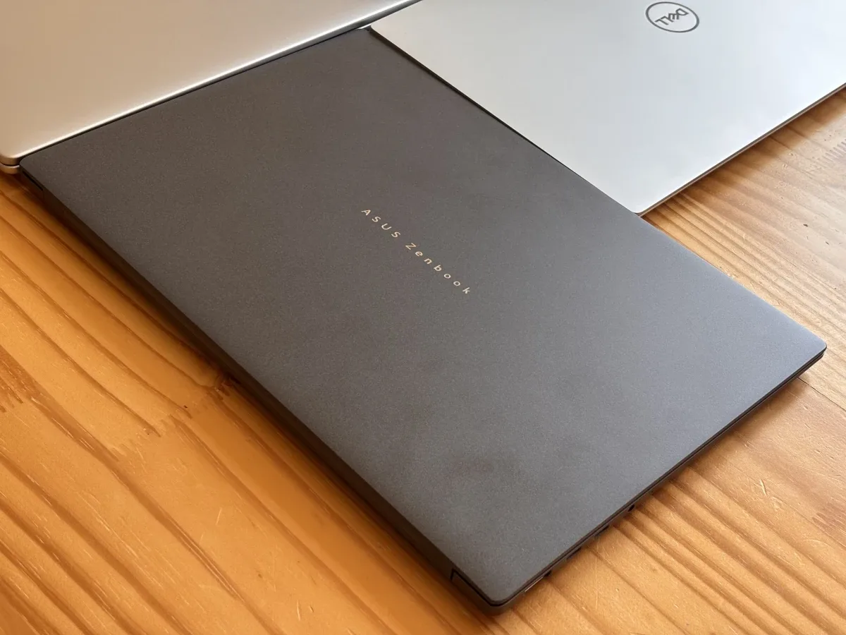 Notebook aberto sobre uma escrivaninha de madeira com iluminação natural indireta