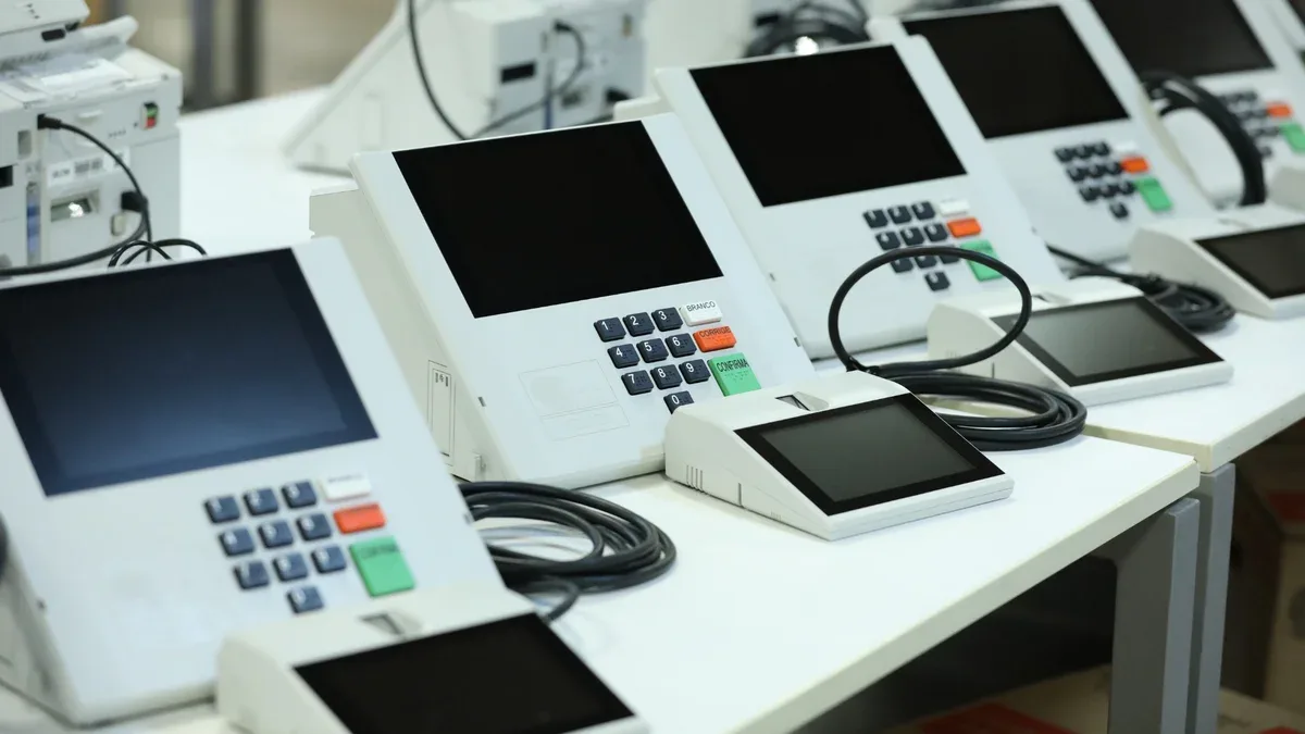 Urna eletrônica posicionada em mesa de seção eleitoral pronta para votação